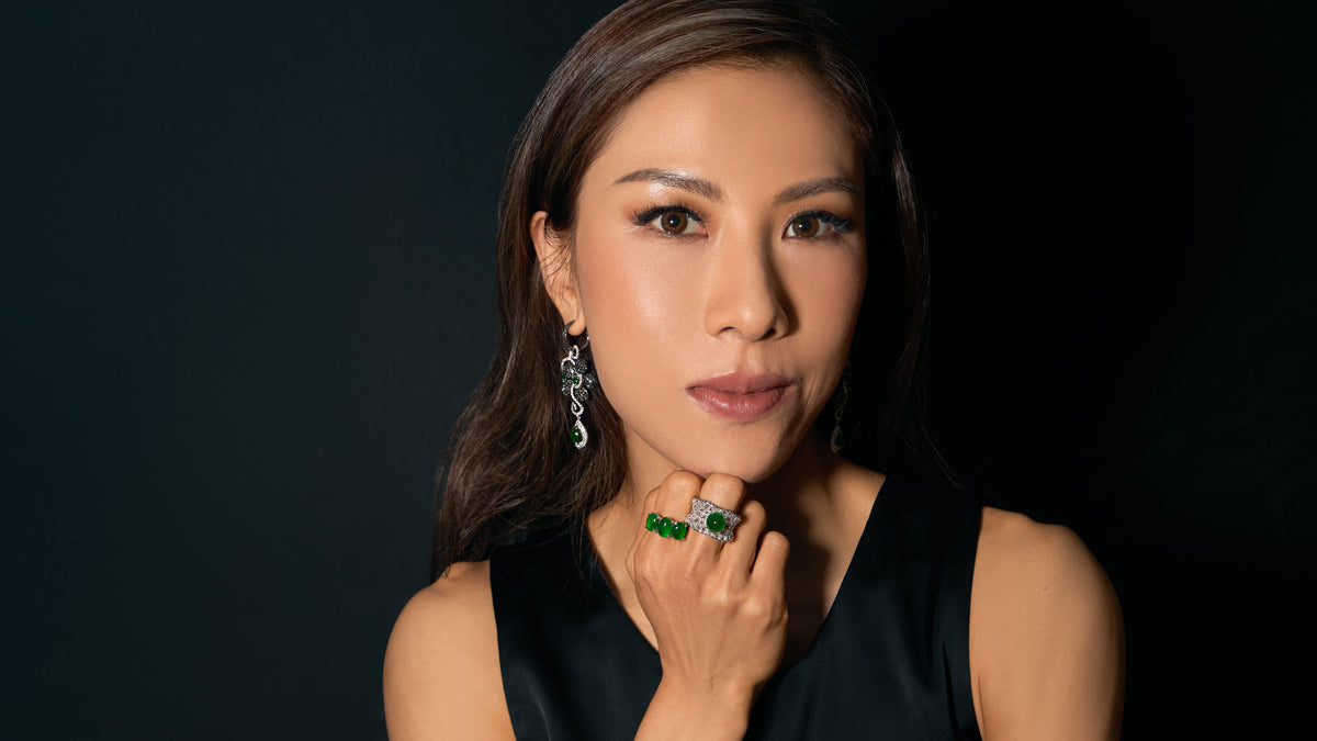 Editorial portrait of model looking directly at camera with one hand gently touching her chin, wearing The Oval Mosaic Ring and The Trilogy Oval Cabochon Ring on her fingers, and The Black Diamond Floral Earrings, demonstrating the pieces' architectural restraint and suitability for daily wear.