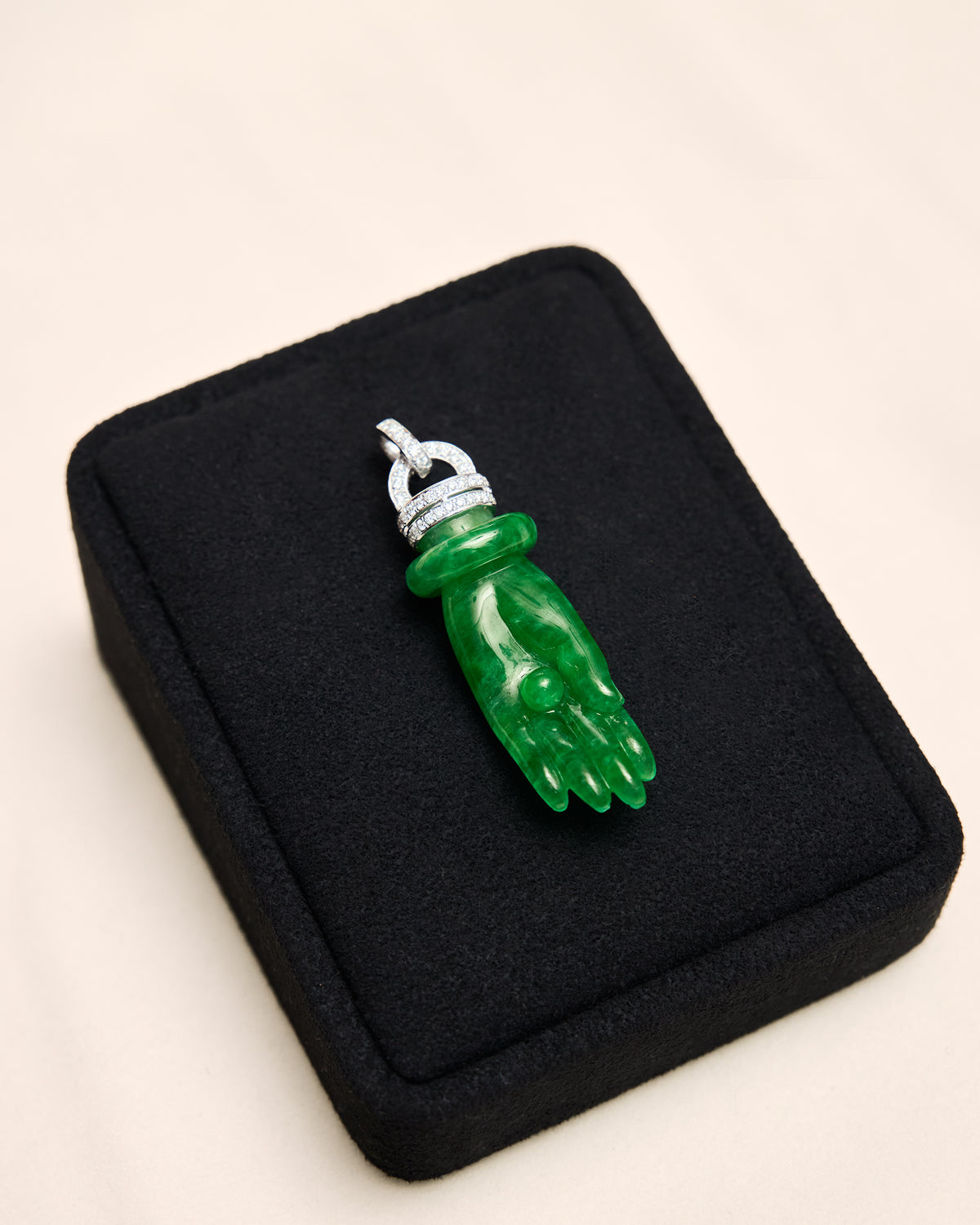 Macro detail of the finely carved jadeite palm and central sphere, framed by the precise pavé diamond rows without obscuring the stone's surface.