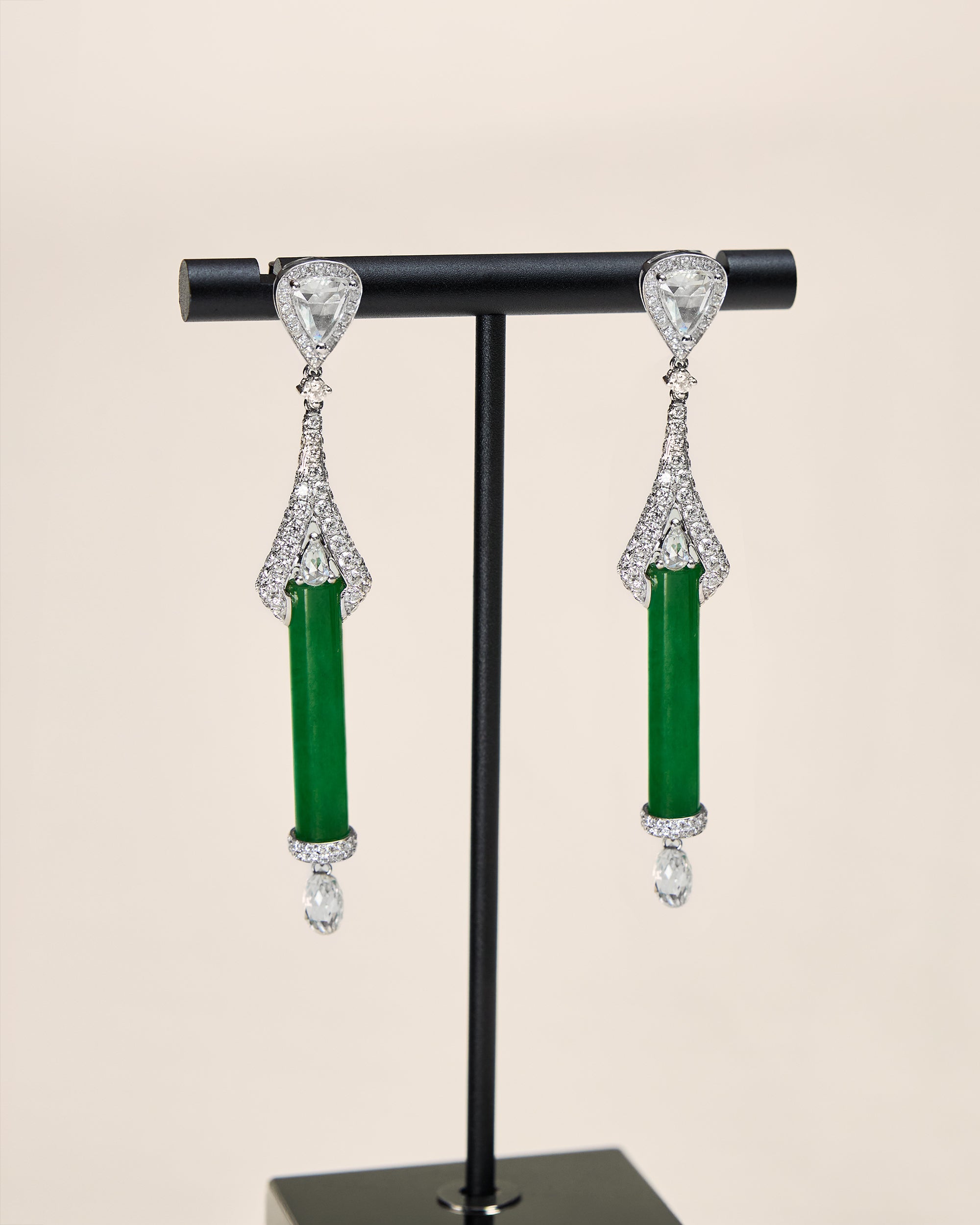 Close front view of The Cylinder Drop Earrings showing the pavé diamond fan frame narrowing at the apex and widening to hold the cylindrical jadeite.