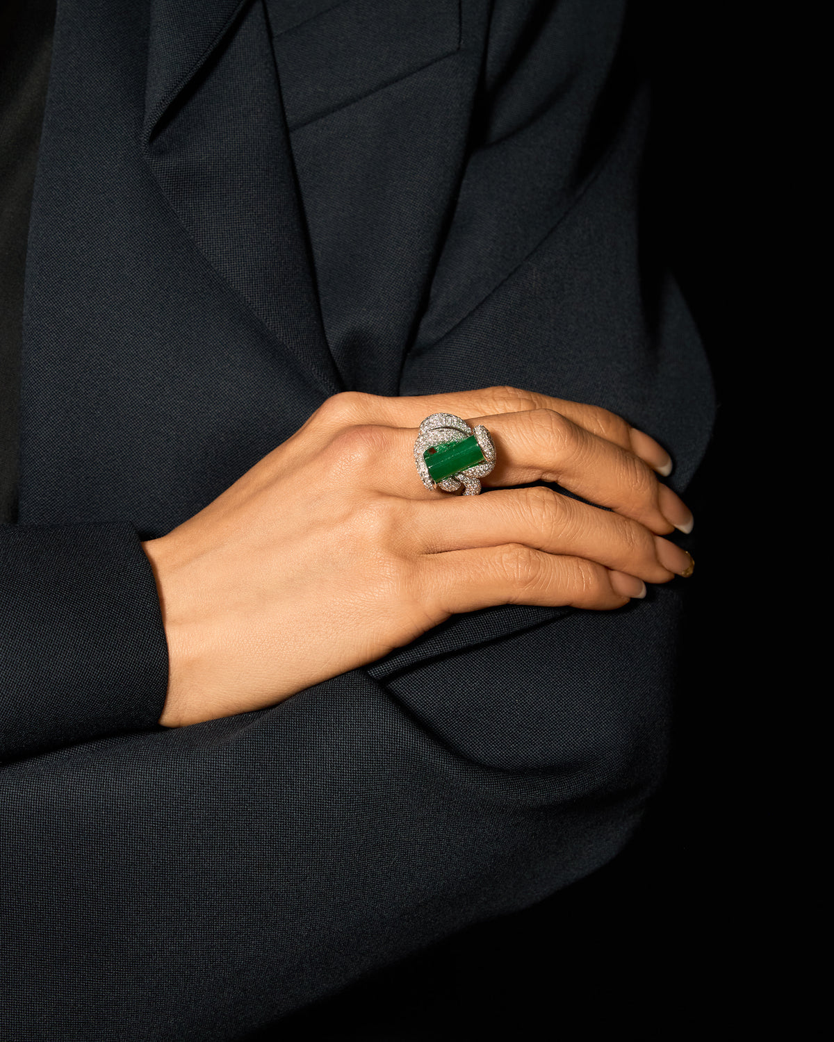 The Cylinder Knot Ring worn on a hand, showcasing the bold architectural presence of the upright cylinder and the continuous shimmer of the pavé band.