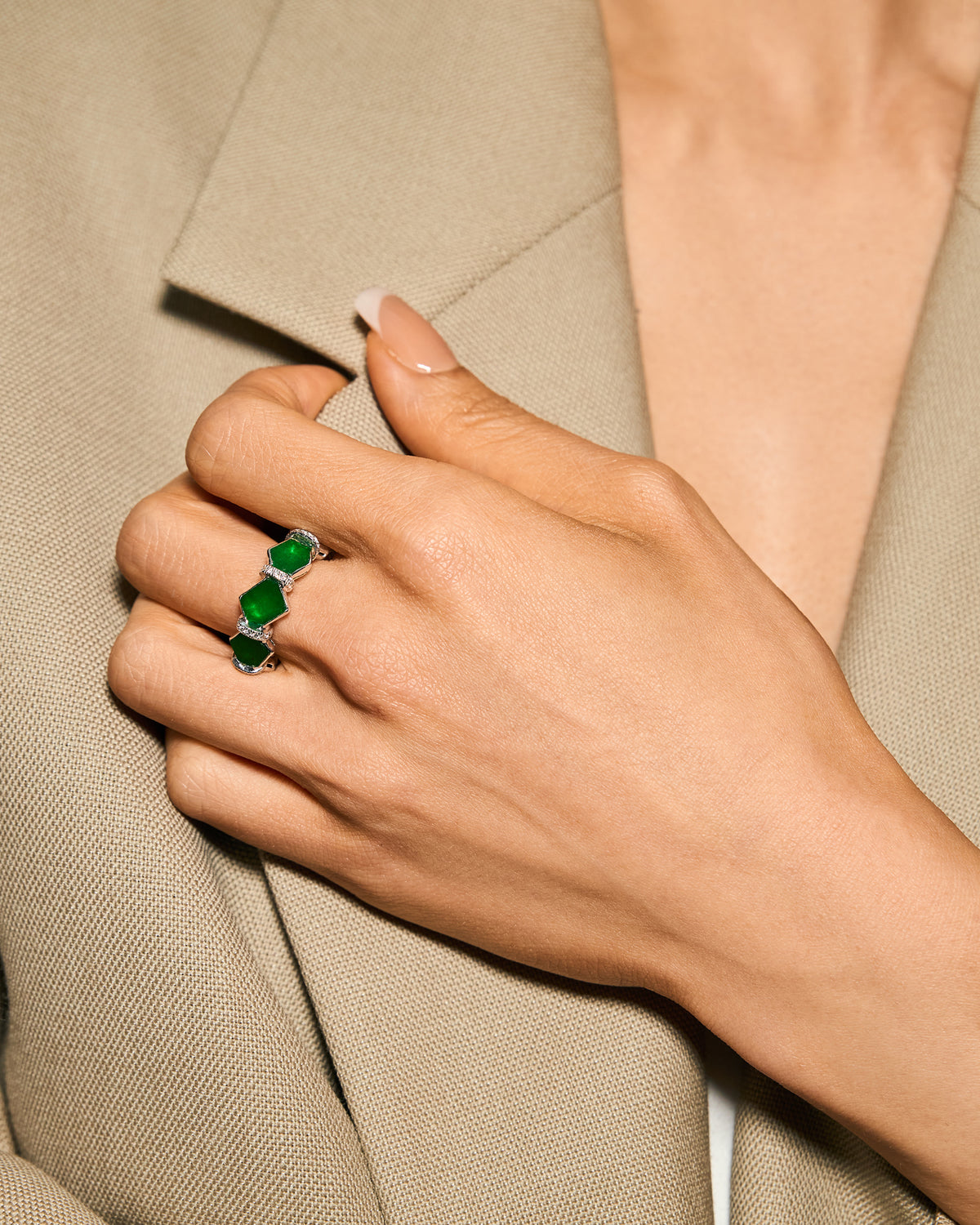The Eternity Ring worn on a hand resting at the collar, showcasing the grounded silhouette and the subtle, shifting kite-like edges of the hexagonal stones.