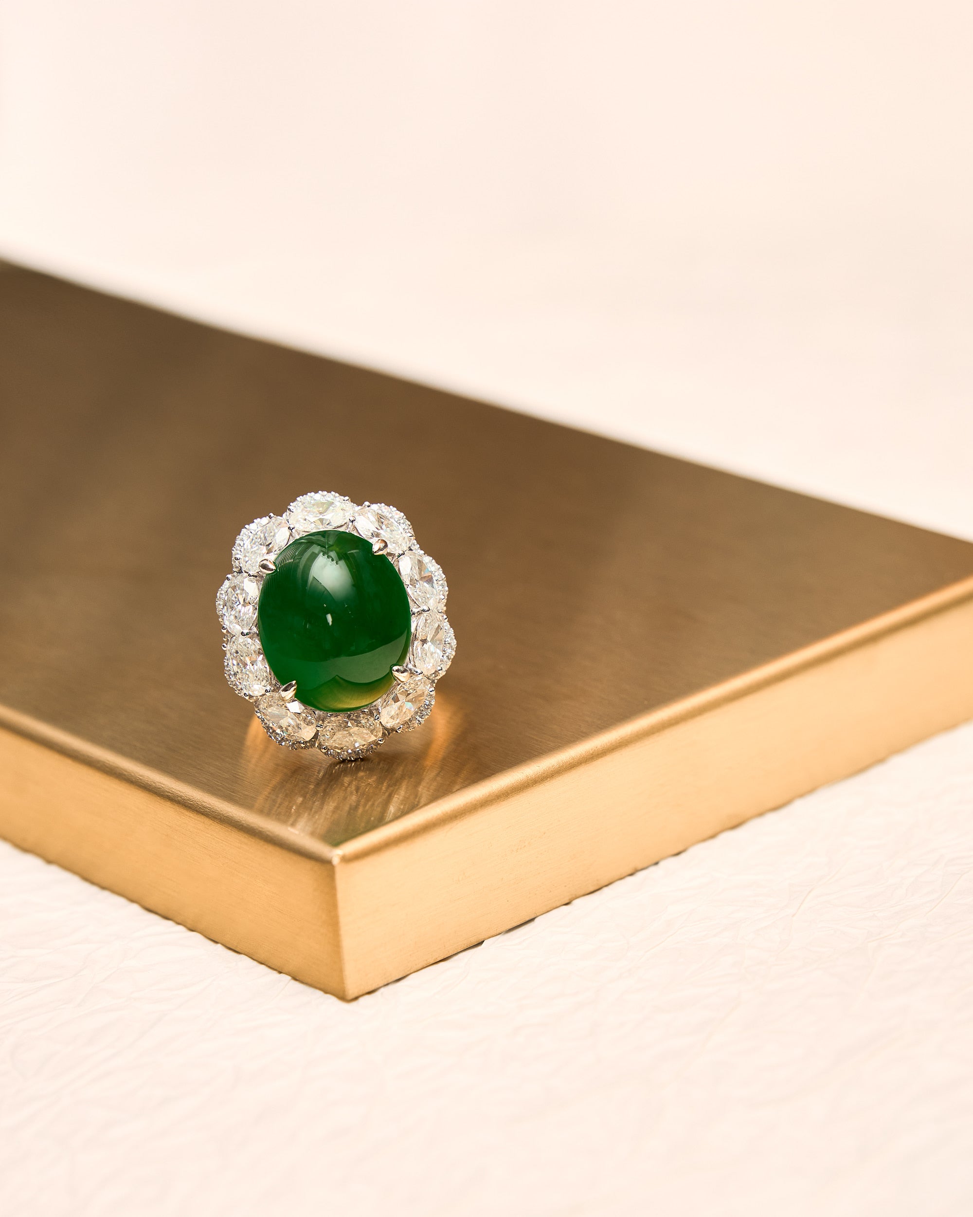 Front view of The Oval Cabochon Ring showing the structured diamond border and the central oval jadeite dome.