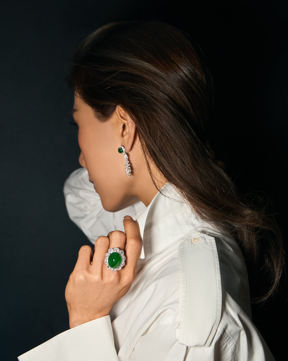 The Oval Cabochon Ring worn on a model's hand, showcasing the structured diamond border and the central oval jadeite dome.