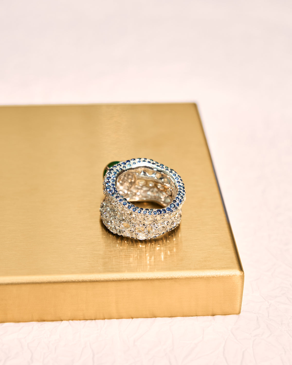 Rear view of The Oval Mosaic Ring revealing the pavé diamond and continuous sapphire border detail along the shank, with the interior of the band visible.