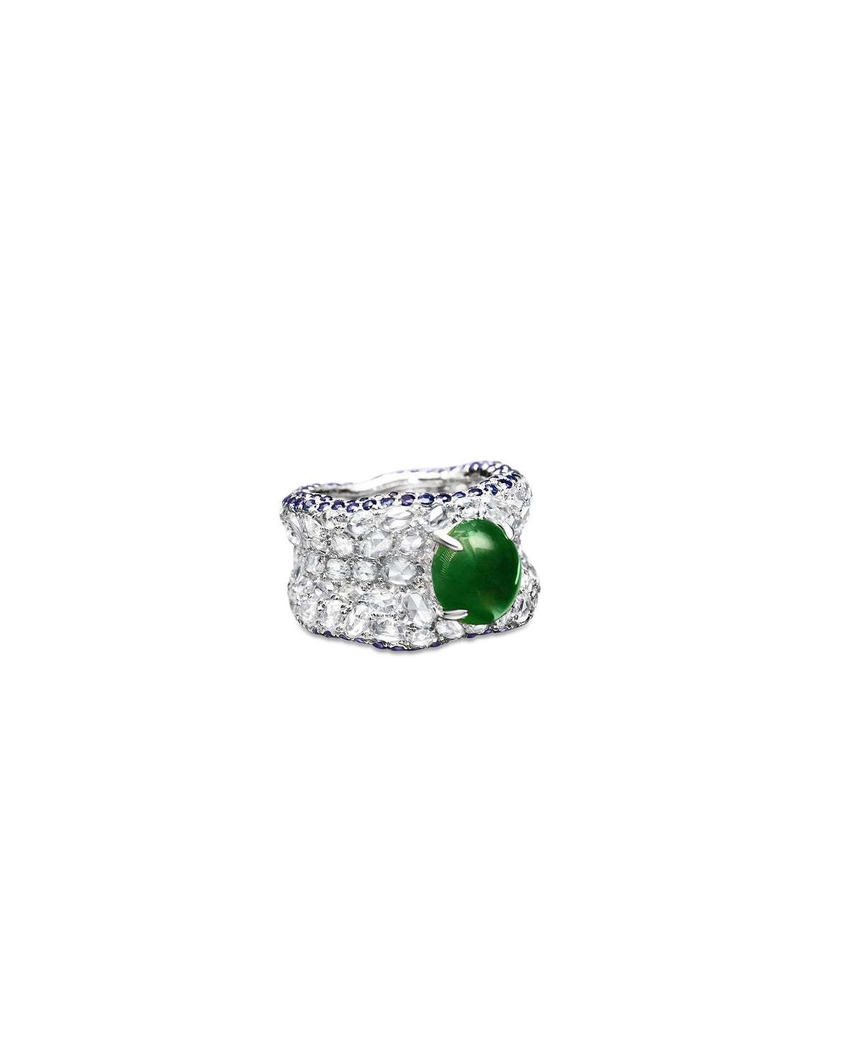 Three-quarter front view of The Oval Mosaic Ring on a white background, showing the intense green oval jadeite cabochon with wide rose-cut diamond pavé and sapphire borders.
