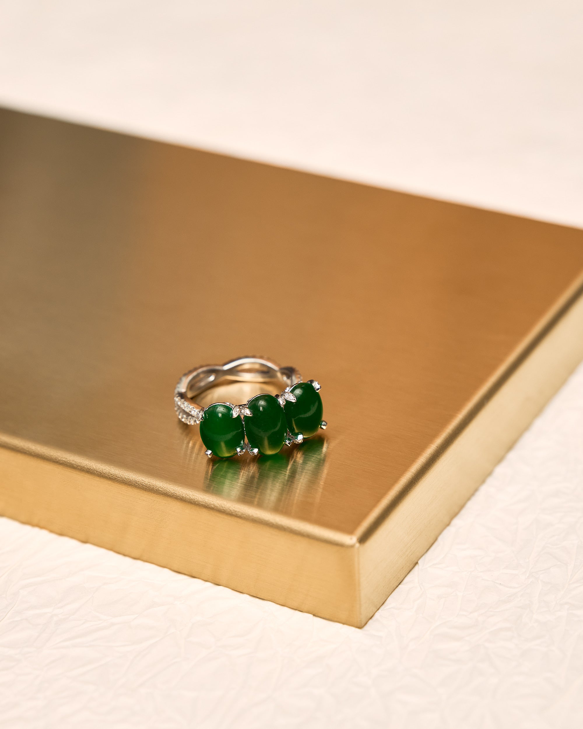 Top-down view of The Trilogy Oval Cabochon Ring showing the centre stone flanked by two smaller ovals and the interlocking pavé diamond band.