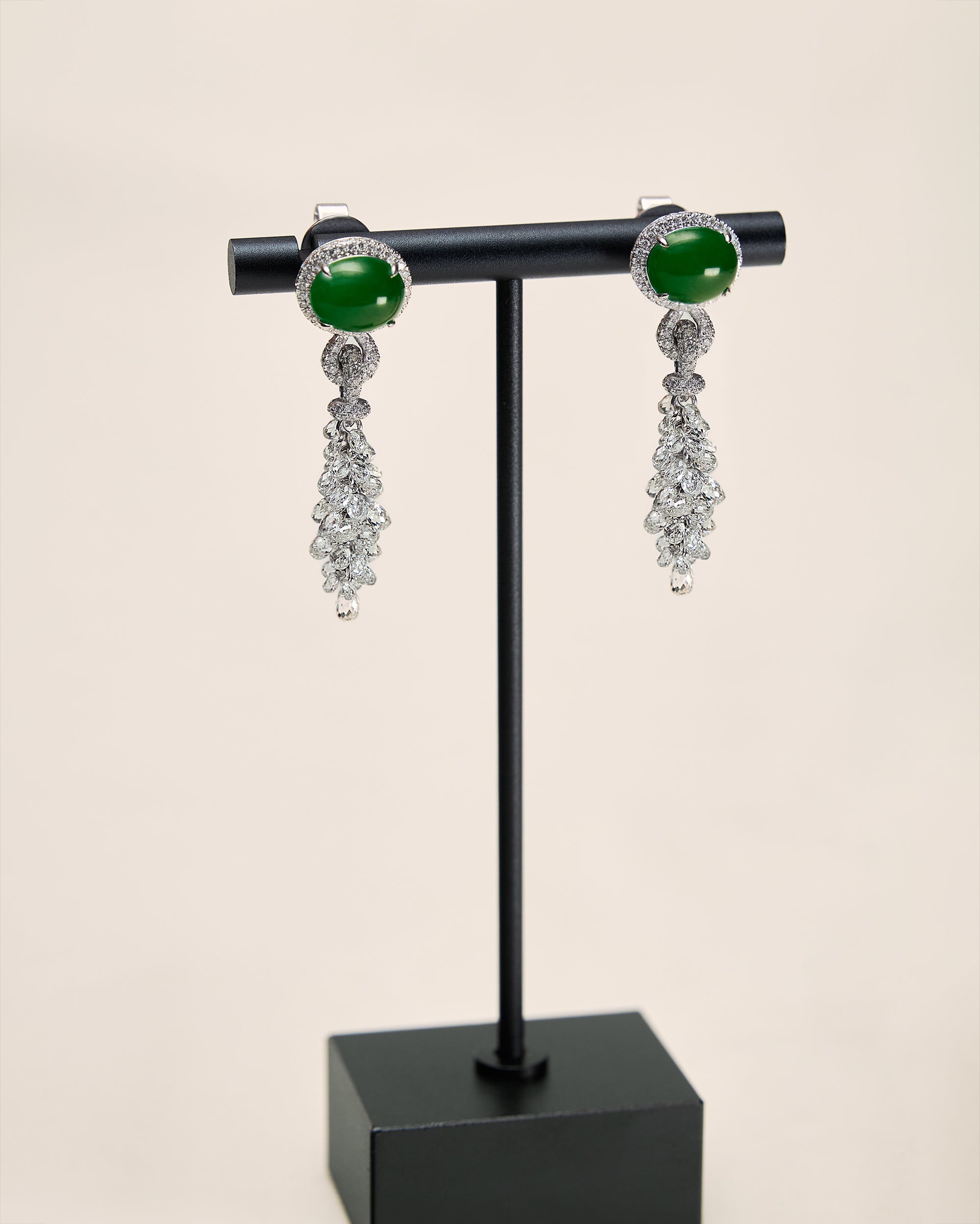 Close front view of The East-West Oval Cabochon Drop Earrings showing the horizontal cabochon, structured diamond halo, and cascading briolette diamonds.