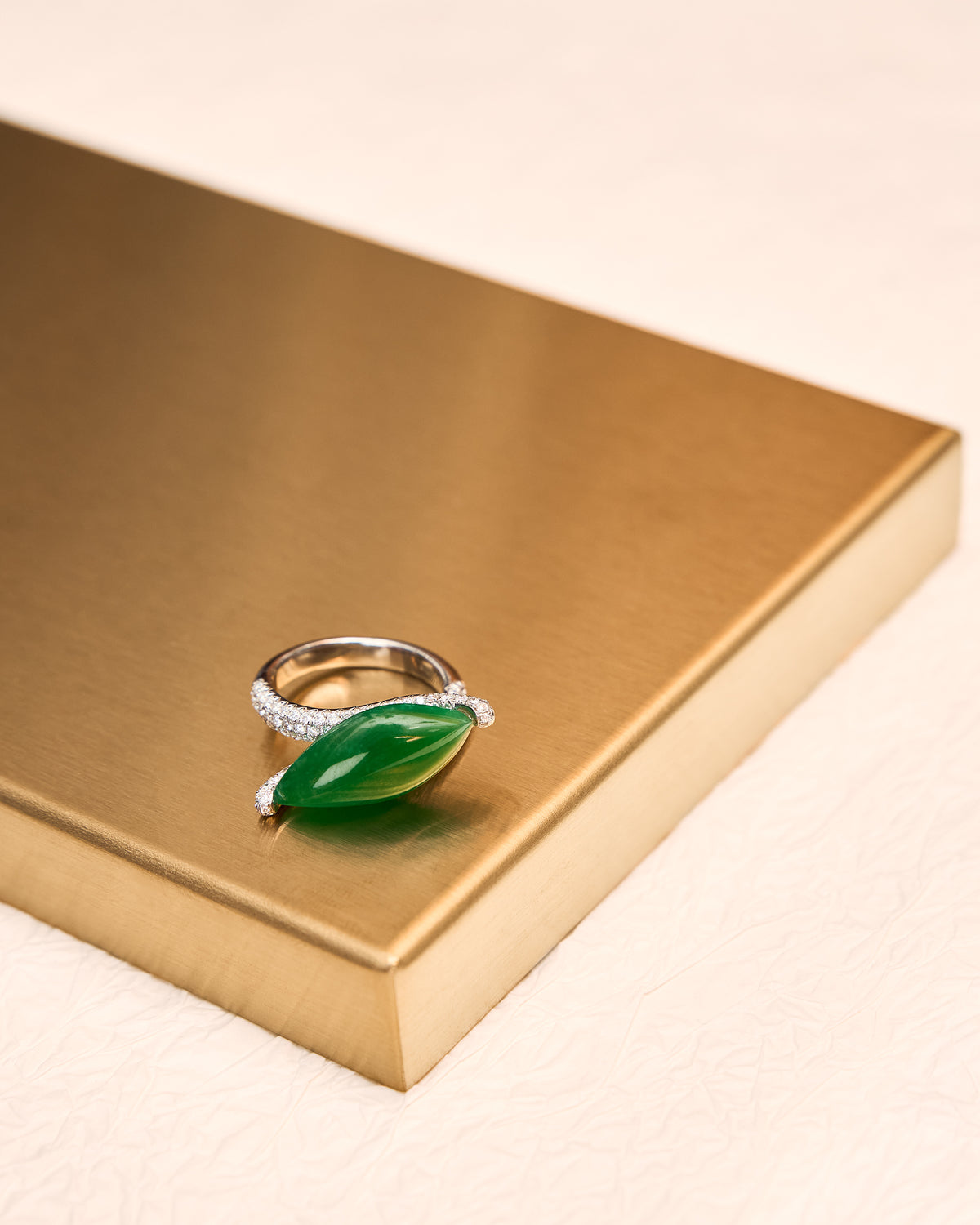 Top-down view of The East-West Marquise Ring on a gold tray, showing the east-west marquise orientation and the bypass band functioning as an open clasp.