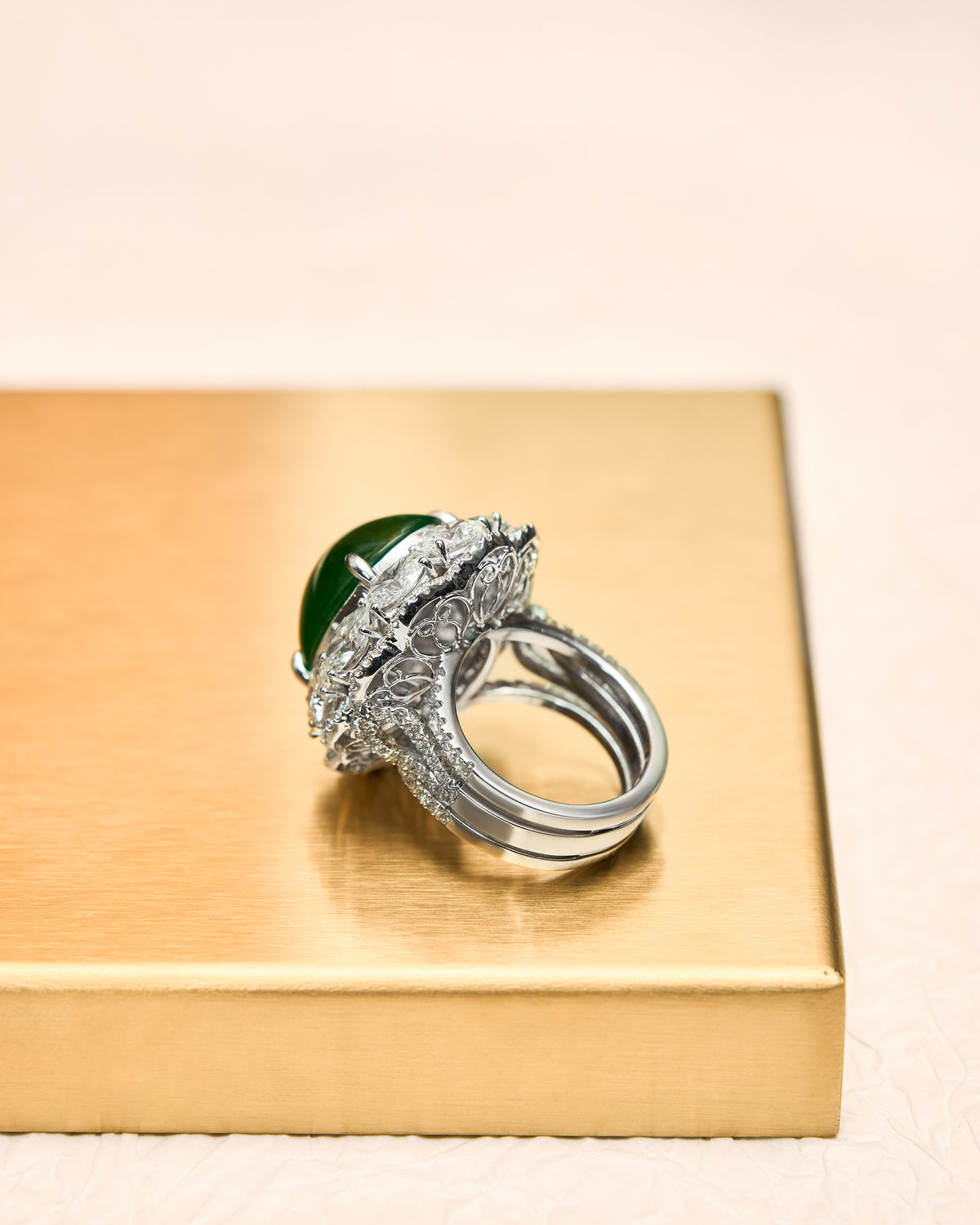 Underside view of The Oval Cabochon Ring, revealing the 18K white gold basket setting that secures the oval jadeite cabochon, and the polished interior of the three-quarter pavé diamond band.