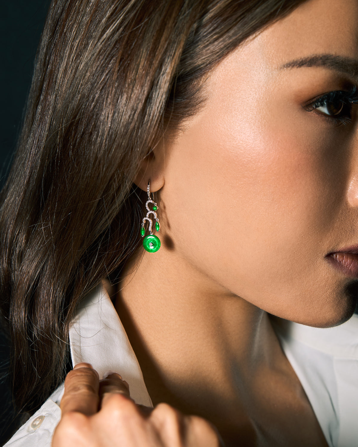 The Tiered Arc Drop Earrings worn on a model in side profile, highlighting the 35 mm drop length and cascading movement along the jawline.