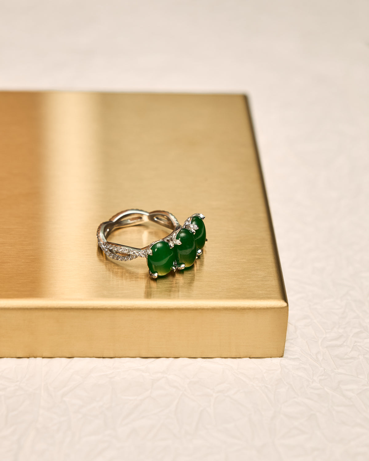 Lateral profile of The Trilogy Oval Cabochon Ring highlighting the three elevated double-convex jadeite domes and the substantial depth of the diamond setting.